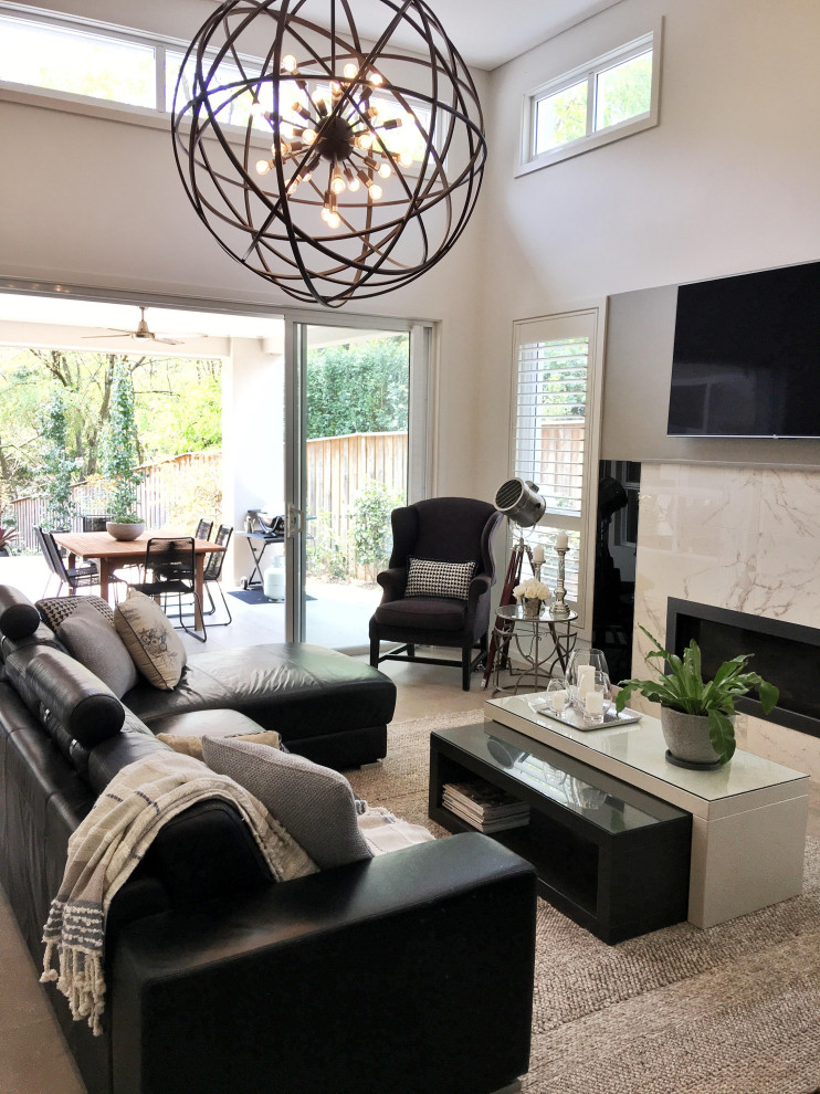 Photo of a large contemporary open concept family room in Sydney with white walls, ceramic floors, a standard fireplace, a stone fireplace surround, a wall-mounted tv, grey floor and vaulted.