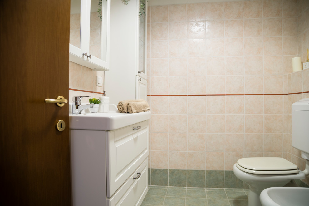 Свежая идея для дизайна: маленькая ванная комната в стиле модернизм с стеклянными фасадами, белыми фасадами, раздельным унитазом, розовой плиткой, керамогранитной плиткой, белыми стенами, полом из керамогранита, душевой кабиной, накладной раковиной, столешницей из искусственного кварца, зеленым полом, душем с раздвижными дверями, белой столешницей, тумбой под одну раковину и подвесной тумбой для на участке и в саду - отличное фото интерьера