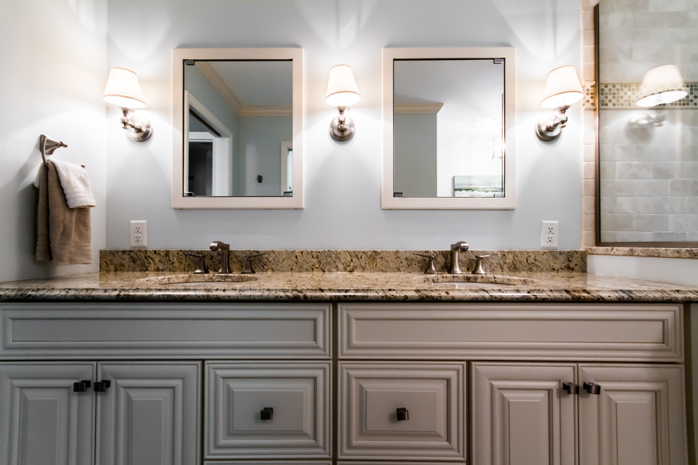 Inspiration for a mid-sized beach style master bathroom in St Louis with raised-panel cabinets, white cabinets, an alcove tub, a corner shower, beige tile, ceramic tile, blue walls, porcelain floors, an undermount sink, granite benchtops, beige floor and a hinged shower door.