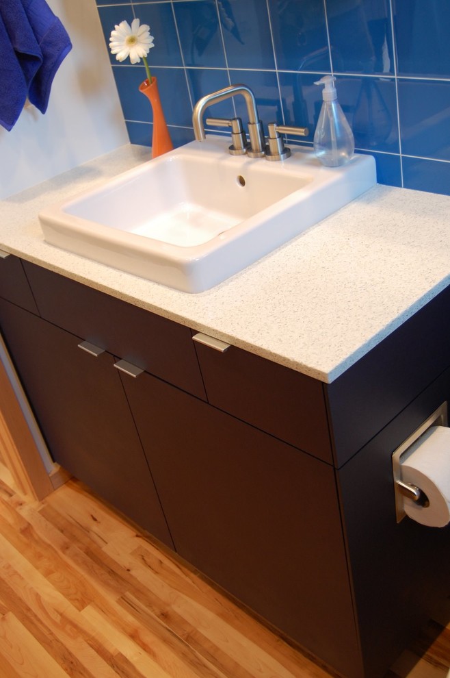 Photo of a contemporary 3/4 bathroom in Minneapolis with a vessel sink, flat-panel cabinets, dark wood cabinets, recycled glass benchtops, blue tile, glass tile and white walls.