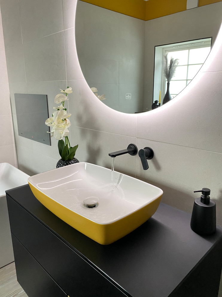 Large contemporary bathroom in Other with flat-panel cabinets, black cabinets, a freestanding bath, a walk-in shower, a wall mounted toilet, white tiles, yellow walls, laminate floors, a vessel sink, glass worktops, brown floors, a hinged door, black worktops, a single sink, a floating vanity unit and porcelain tiles.