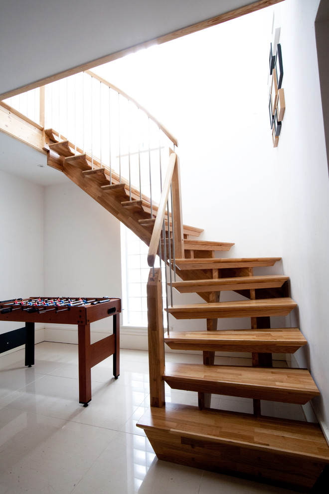 This is an example of a mid-sized contemporary wood l-shaped staircase in Hampshire with open risers.
