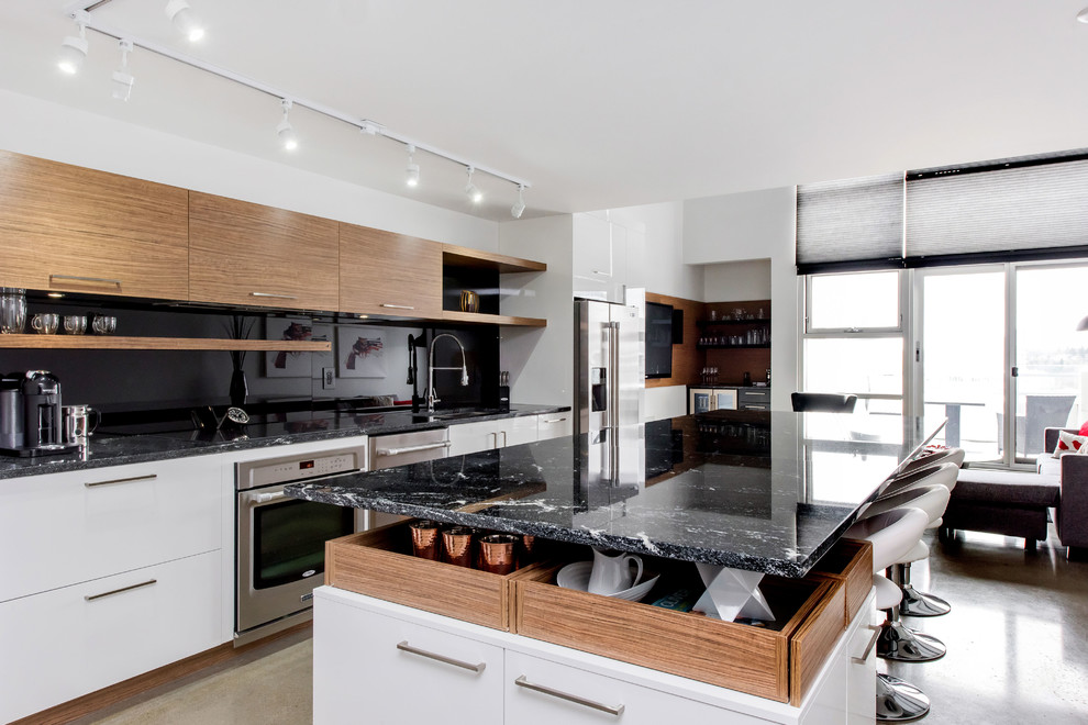 Design ideas for a small modern galley open plan kitchen in Other with a double-bowl sink, flat-panel cabinets, white cabinets, granite benchtops, black splashback, glass sheet splashback, stainless steel appliances, concrete floors and with island.