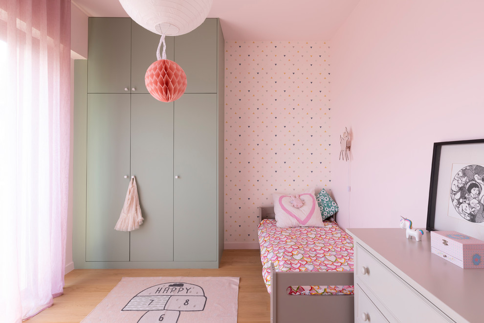 Contemporary kids' bedroom in Paris with pink walls, light hardwood floors and beige floor for kids 4-10 years old and girls.