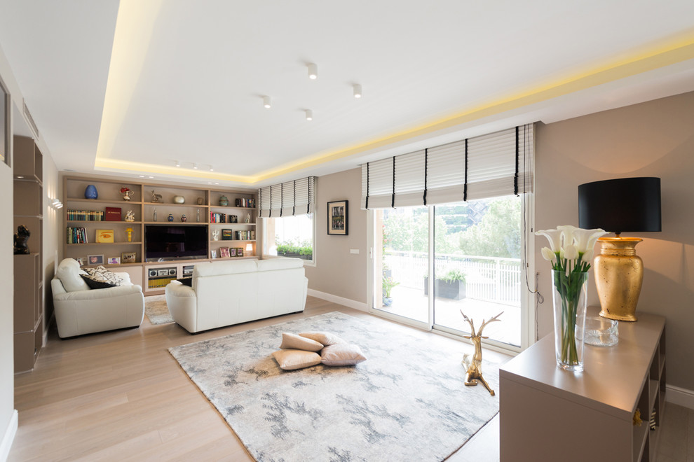 This is an example of a large contemporary formal open concept living room in Barcelona with grey walls, light hardwood floors, a built-in media wall and no fireplace.