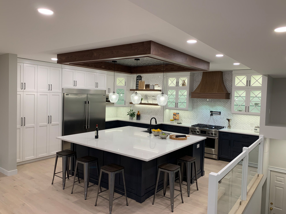 Inspiration for a large transitional light wood floor and coffered ceiling kitchen remodel with an undermount sink, shaker cabinets, white cabinets, quartzite countertops, stainless steel appliances, an island and white countertops