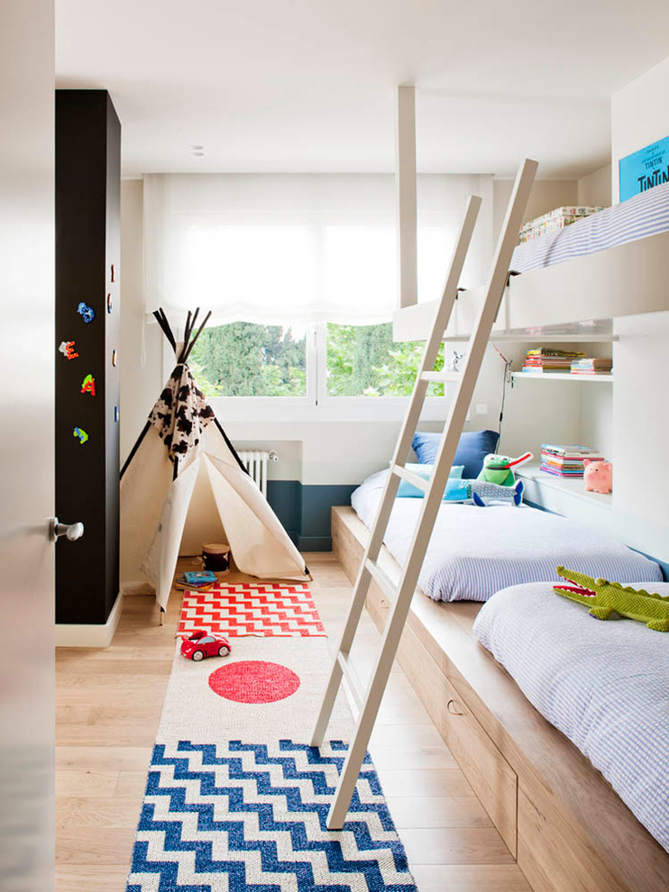 Small scandinavian gender-neutral kids' bedroom in Barcelona with beige walls and light hardwood floors for kids 4-10 years old.