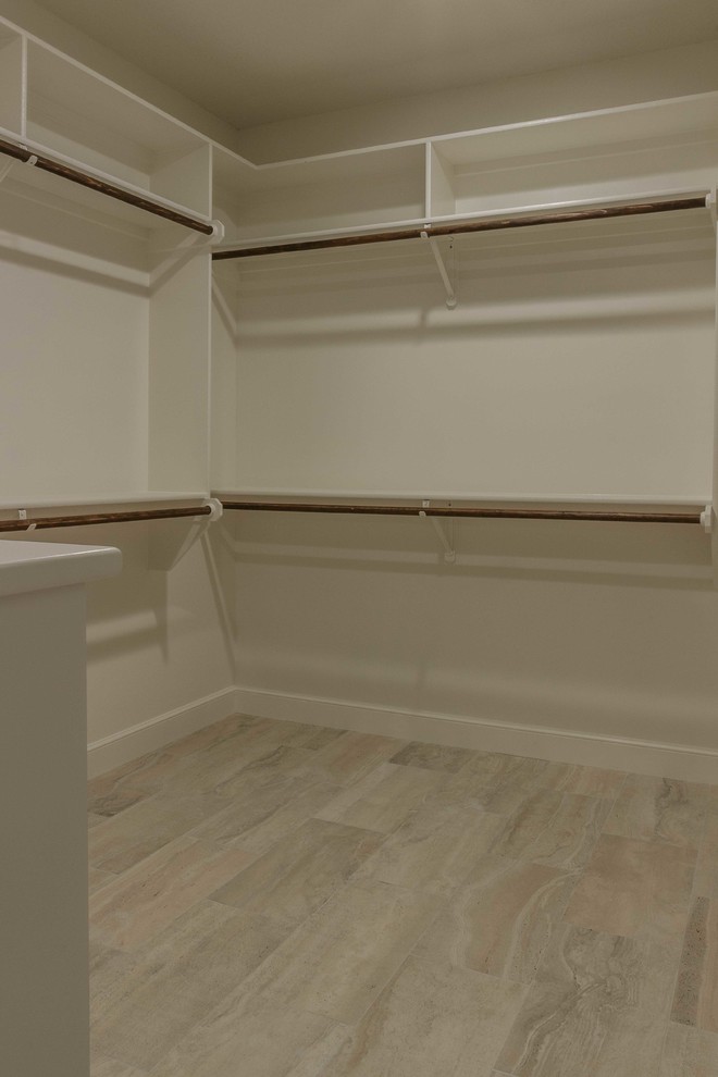 Large transitional gender-neutral walk-in wardrobe in Austin with open cabinets, white cabinets and porcelain floors.
