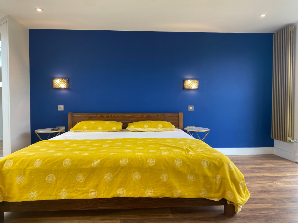 Modelo de dormitorio principal grande con paredes azules, suelo de bambú, suelo marrón, todos los diseños de techos y todos los tratamientos de pared