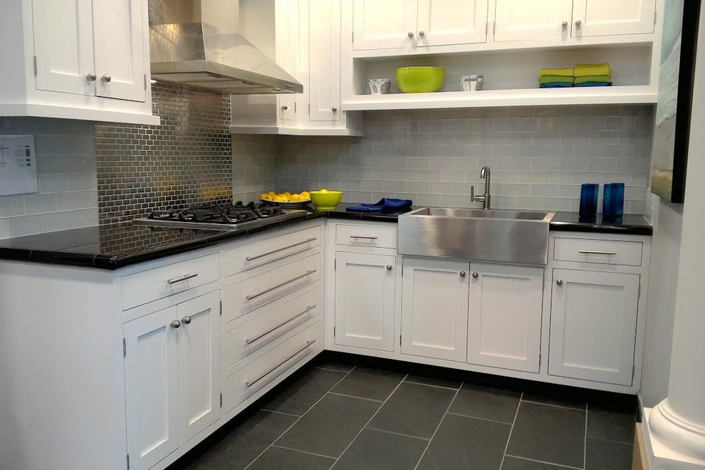 This is an example of a mid-sized country l-shaped separate kitchen in Austin with a farmhouse sink, shaker cabinets, white cabinets, marble benchtops, grey splashback, glass tile splashback, stainless steel appliances, slate floors, no island, grey floor and black benchtop.