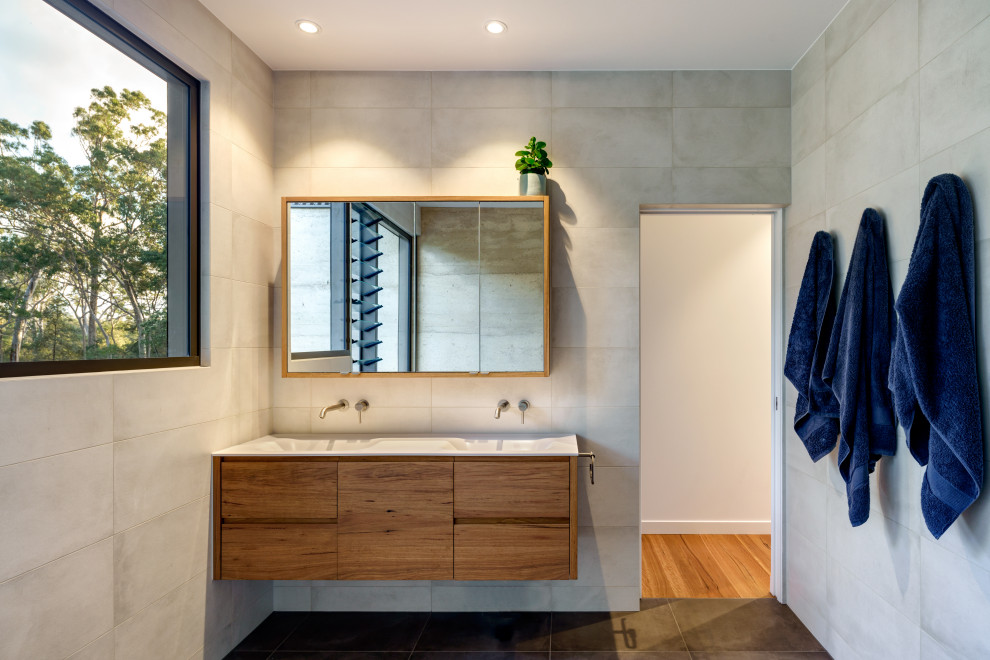 This is an example of a contemporary bathroom in Sunshine Coast with flat-panel cabinets, medium wood cabinets, gray tile, an integrated sink, grey floor, white benchtops, a double vanity and a floating vanity.
