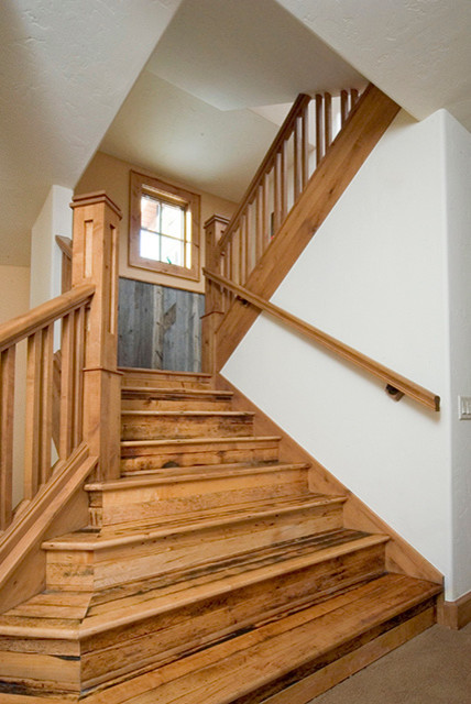 Large country wood u-shaped staircase in Denver with wood risers and wood railing.