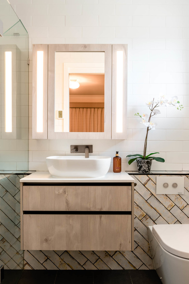 This is an example of a mid-sized transitional master bathroom in Brisbane with flat-panel cabinets, beige cabinets, a wall-mount toilet, beige tile, subway tile, white walls, a vessel sink, black floor, white benchtops, a corner tub, a shower/bathtub combo, ceramic floors, engineered quartz benchtops and an open shower.