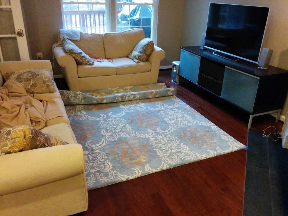 Area rug in small living room with corner fireplace