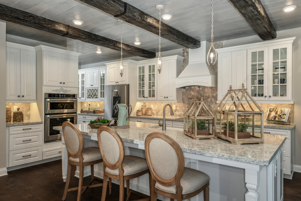 This is an example of a mid-sized country l-shaped kitchen in Orlando with a farmhouse sink, raised-panel cabinets, white cabinets, granite benchtops, mosaic tile splashback, stainless steel appliances, with island, brown floor, grey splashback, dark hardwood floors and grey benchtop.