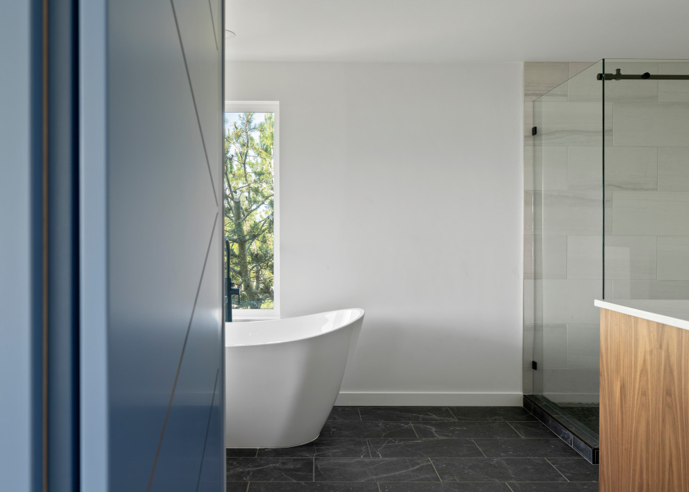 Example of a large transitional single-wall vinyl floor, brown floor and vaulted ceiling open concept kitchen design in Seattle with an undermount sink, shaker cabinets, white cabinets, quartz countertops, white backsplash, quartz backsplash, stainless steel appliances, an island and white countertops