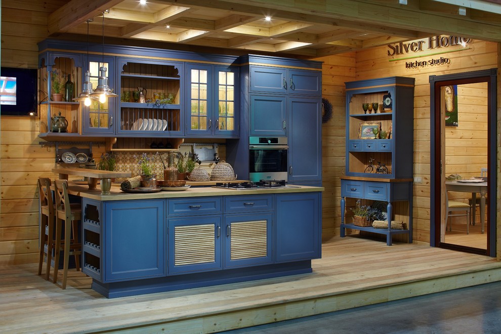 This is an example of a mid-sized country single-wall eat-in kitchen in Moscow with recessed-panel cabinets, blue cabinets, laminate benchtops, beige splashback and light hardwood floors.