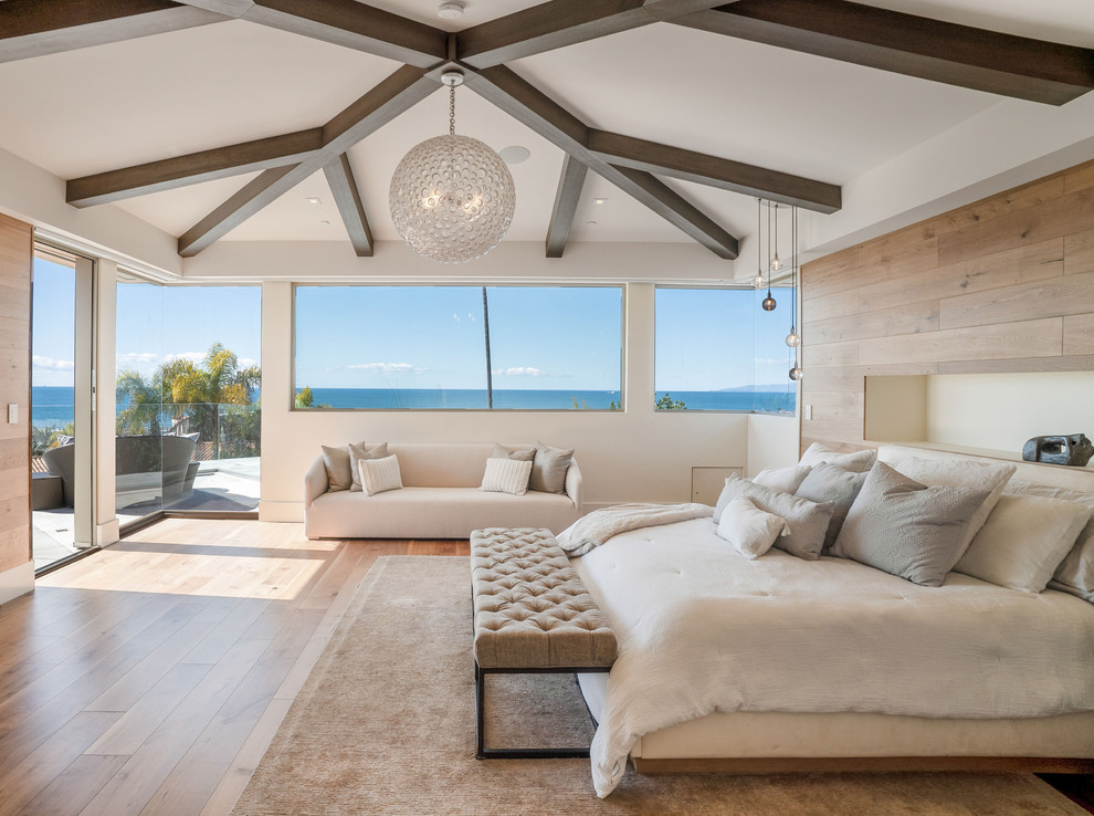 Design ideas for a large beach style master bedroom in Los Angeles with white walls, light hardwood floors and no fireplace.