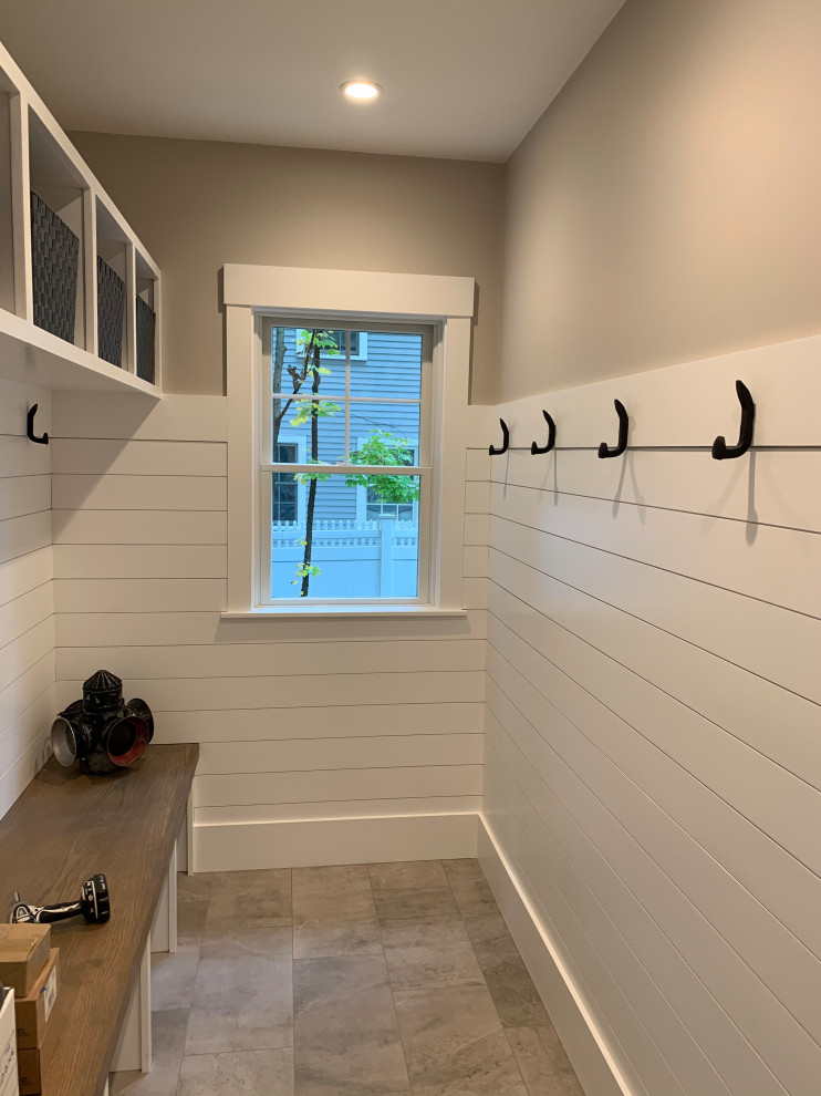 Photo of a large arts and crafts mudroom in Boston with beige walls, granite floors, a single front door, a white front door, grey floor and wood walls.