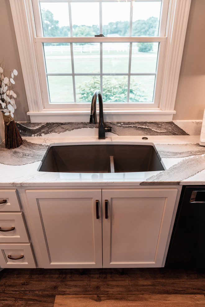 Inspiration for a large transitional l-shaped medium tone wood floor and brown floor open concept kitchen remodel with an undermount sink, flat-panel cabinets, white cabinets, quartz countertops, multicolored backsplash, quartz backsplash, black appliances, an island and multicolored countertops
