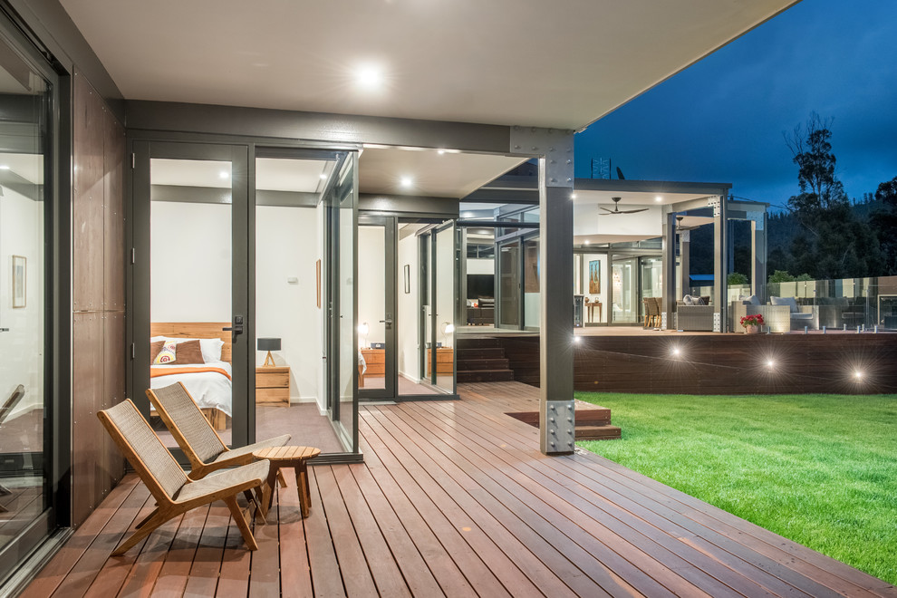 Inspiration for an expansive contemporary side yard deck in Melbourne with a roof extension.
