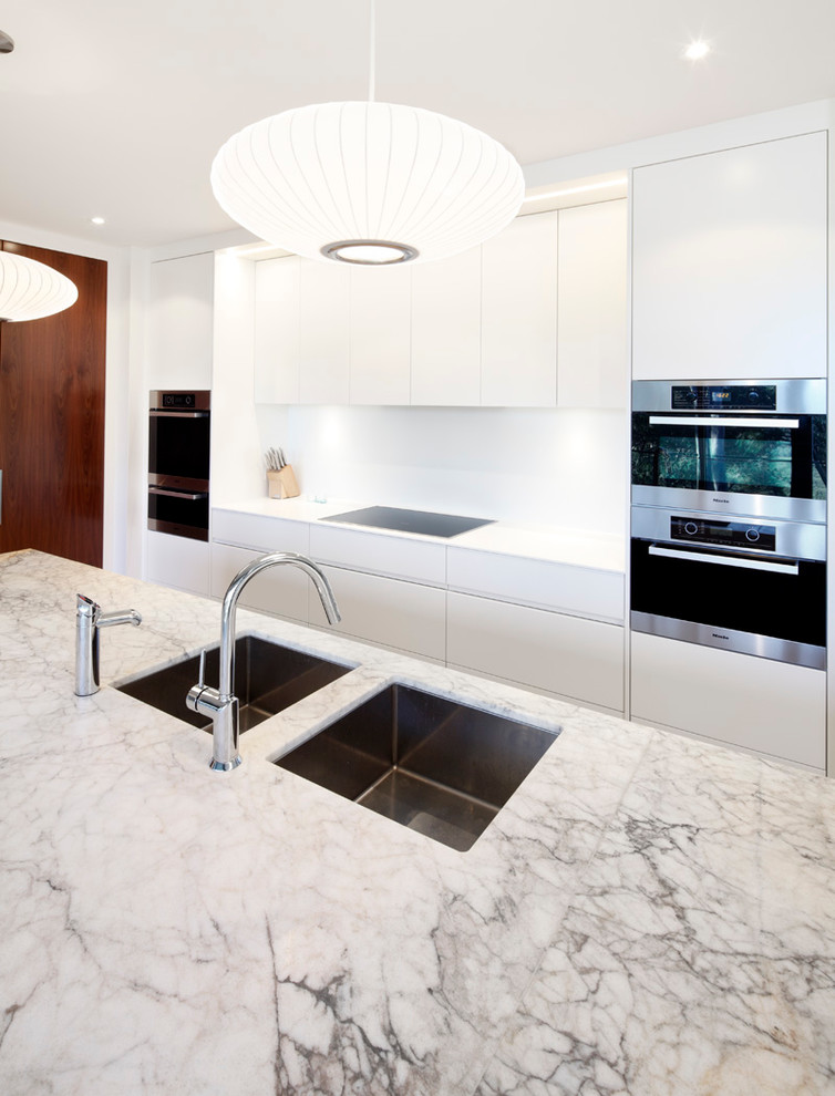 Design ideas for a mid-sized contemporary single-wall eat-in kitchen in Sydney with a double-bowl sink, flat-panel cabinets, white cabinets, marble benchtops, white splashback, stainless steel appliances, light hardwood floors and with island.