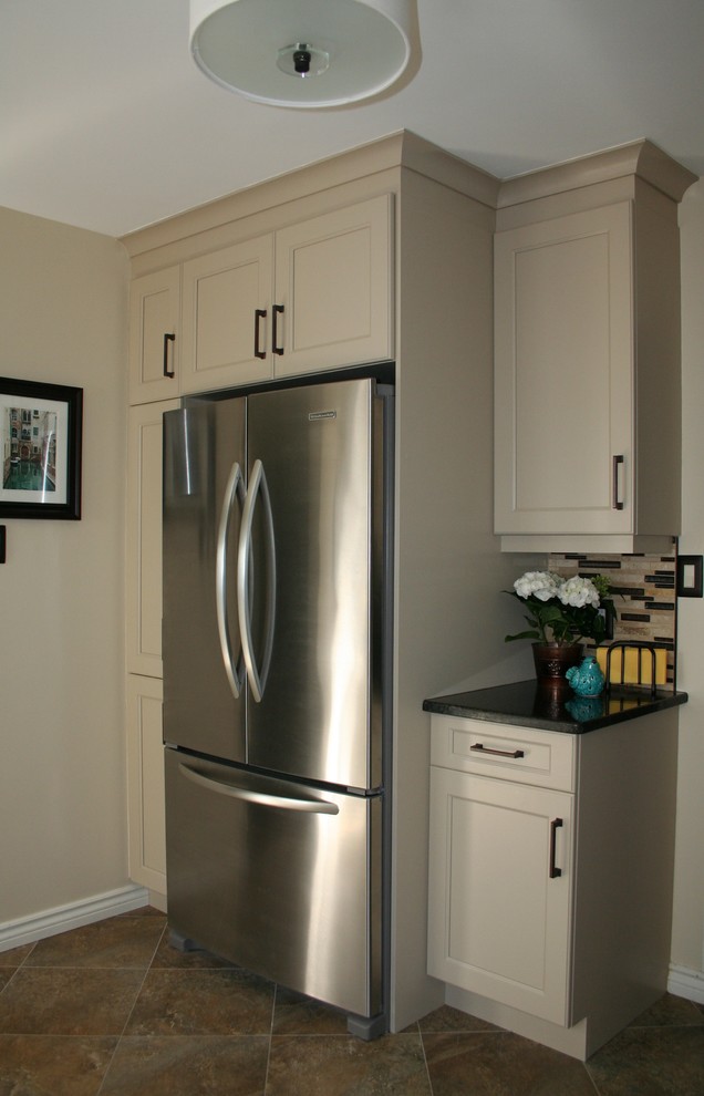 Inspiration for a small transitional l-shaped enclosed kitchen remodel in Ottawa with an undermount sink, shaker cabinets, beige cabinets, granite countertops, glass sheet backsplash, stainless steel appliances and no island