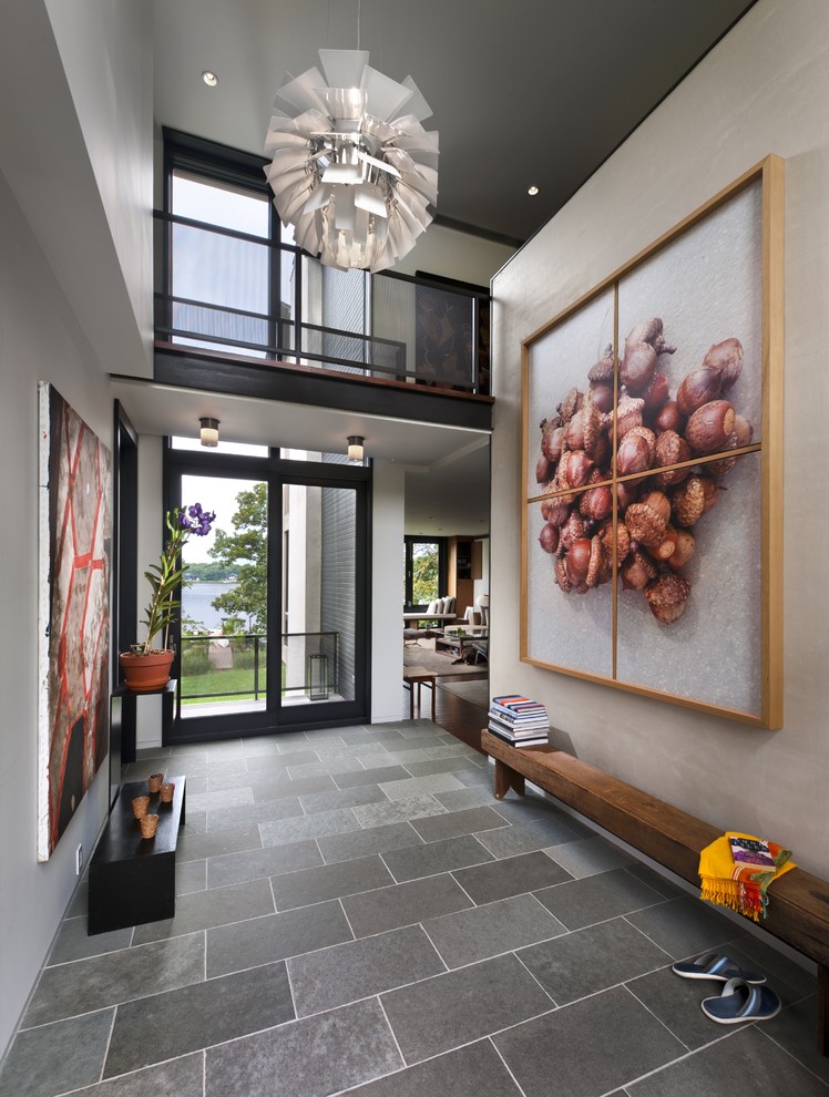 Inspiration for a contemporary entryway in New York with grey walls, slate floors and a glass front door.