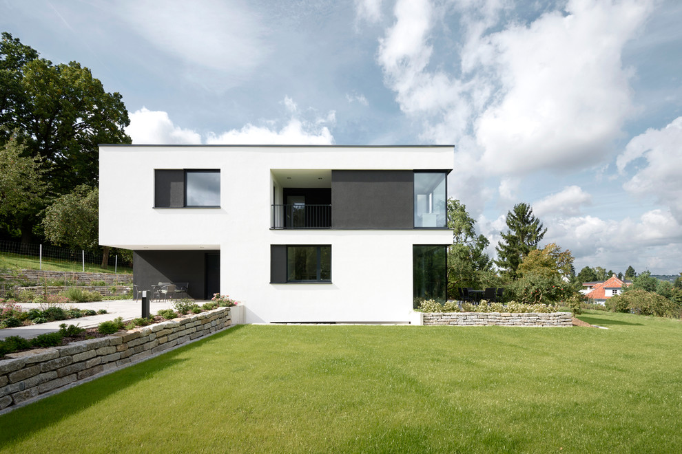 Inspiration for a large modern two-storey stucco white exterior in Nuremberg with a flat roof.