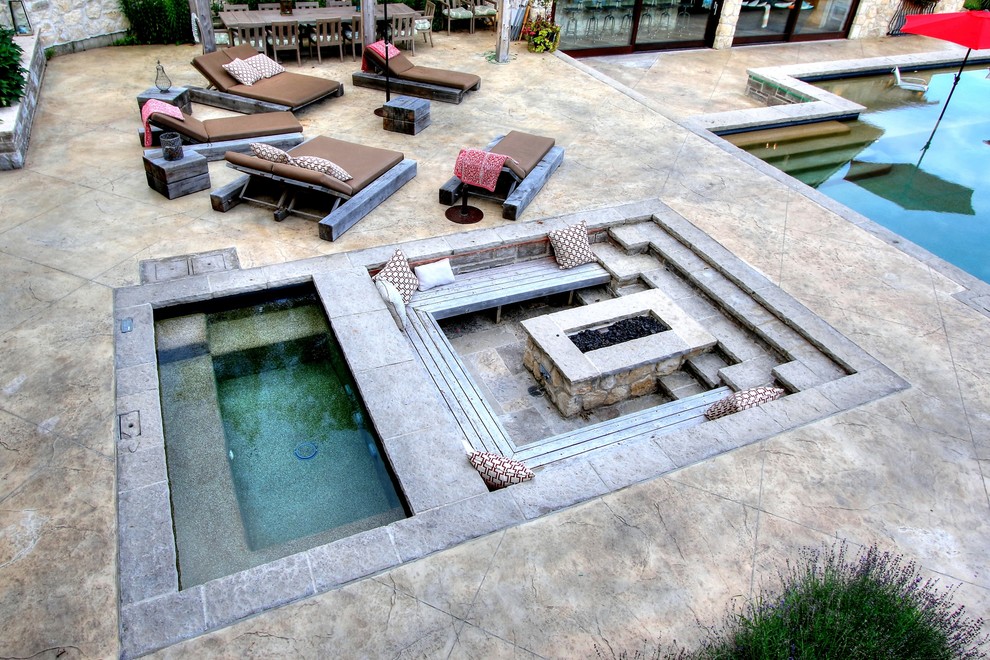 This is an example of a large mediterranean front yard rectangular pool in Toronto with a hot tub and stamped concrete.