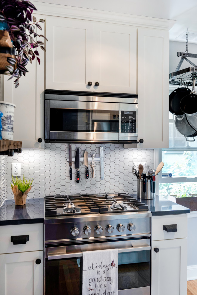 Design ideas for a small modern galley open plan kitchen in Minneapolis with an undermount sink, shaker cabinets, white cabinets, quartzite benchtops, white splashback, porcelain splashback, stainless steel appliances, light hardwood floors, brown floor and blue benchtop.