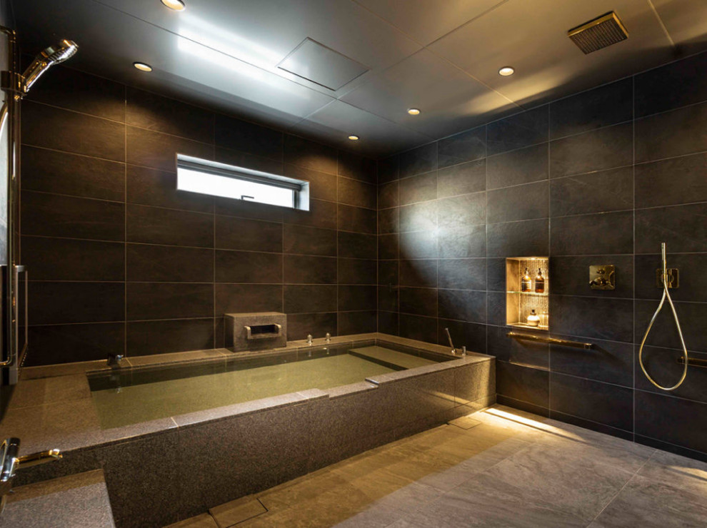 和風のおしゃれな浴室 (大型浴槽、黒い壁、グレーの床、折り上げ天井) の写真
