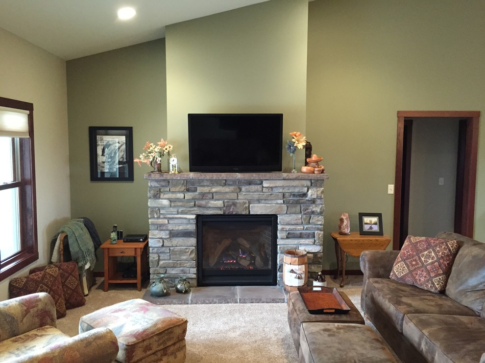 Mid-sized traditional formal open concept living room in Minneapolis with beige walls, carpet, a standard fireplace, a stone fireplace surround, a wall-mounted tv and beige floor.