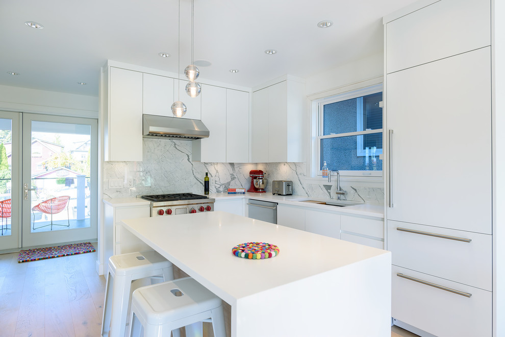 This is an example of a small contemporary l-shaped eat-in kitchen in Vancouver with a double-bowl sink, flat-panel cabinets, white cabinets, quartzite benchtops, white splashback, marble splashback, stainless steel appliances, light hardwood floors, with island, brown floor and white benchtop.
