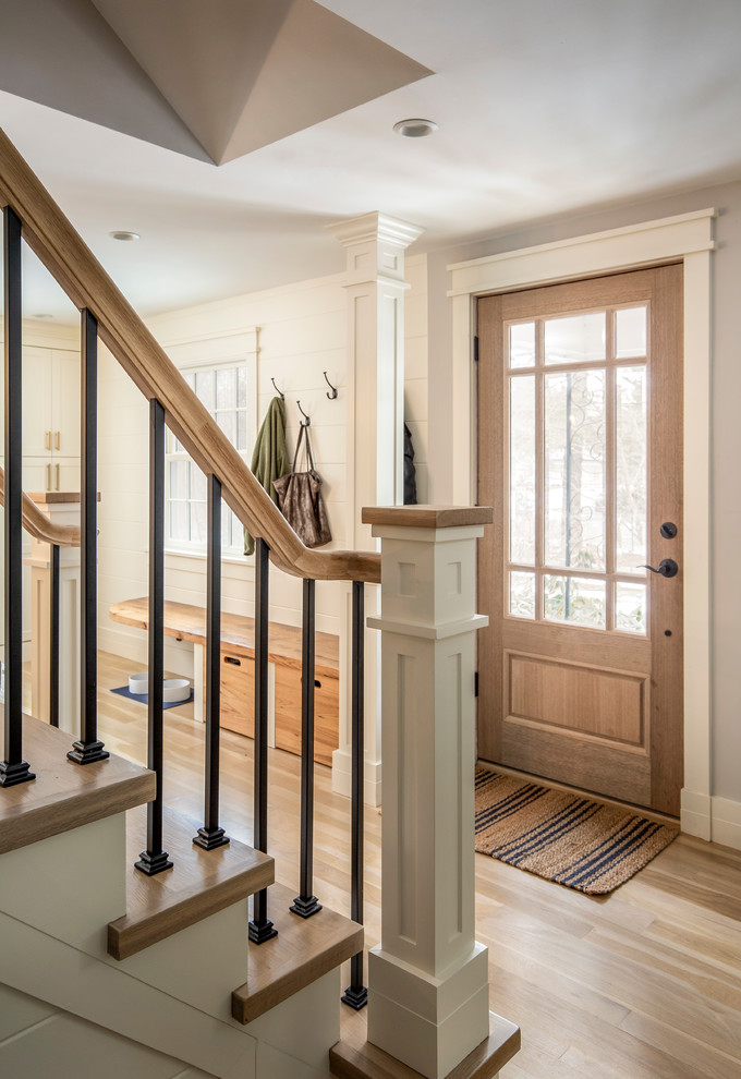 Photo of a mid-sized transitional foyer in Boston with grey walls, light hardwood floors, a single front door and a medium wood front door.