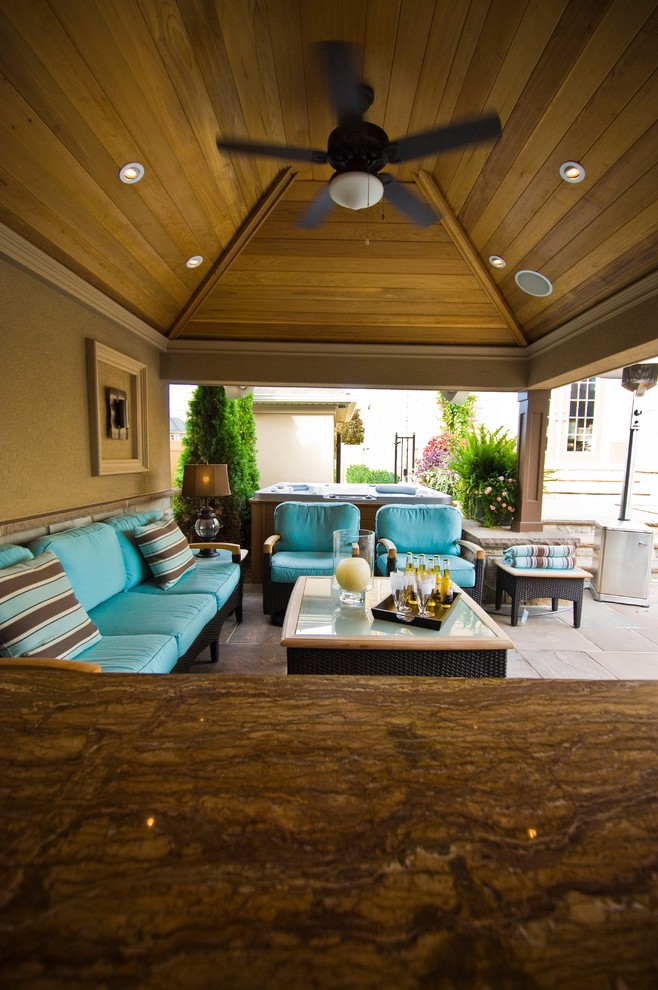 Inspiration for a transitional backyard stone patio kitchen remodel in Toronto with a gazebo