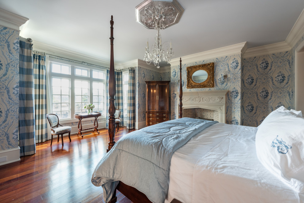 アトランタにある広いシャビーシック調のおしゃれな主寝室 (青い壁、濃色無垢フローリング、標準型暖炉、コンクリートの暖炉まわり、茶色い床、壁紙) のインテリア