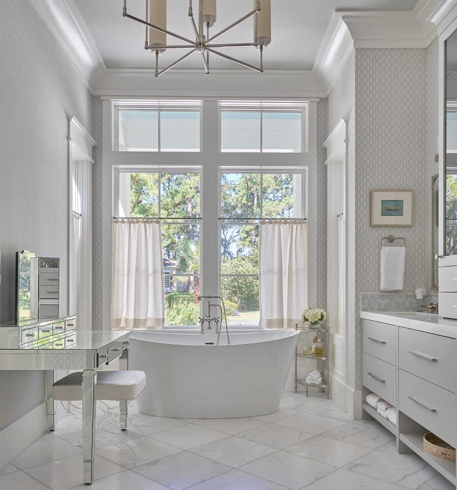 Design ideas for a large transitional master bathroom in Charleston with flat-panel cabinets, grey cabinets, a freestanding tub, gray tile, glass tile, grey walls, marble floors, an undermount sink, marble benchtops, white floor and white benchtops.