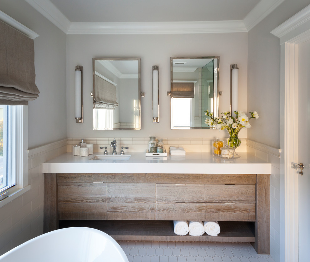 Inspiration for a mid-sized contemporary master bathroom in San Francisco with flat-panel cabinets, brown cabinets, a freestanding tub, white tile, ceramic tile, grey walls, ceramic floors, an undermount sink, onyx benchtops and white floor.
