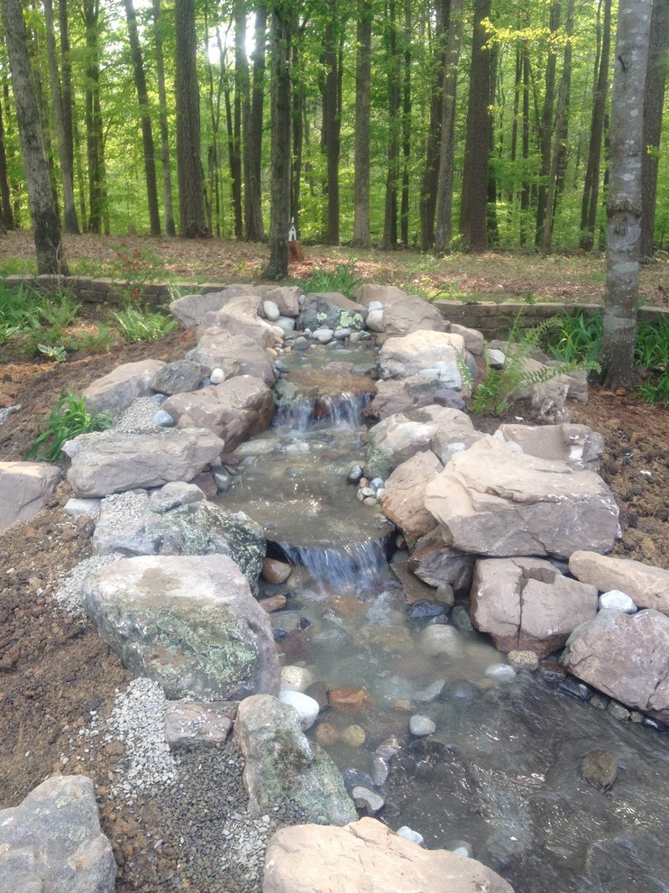 Design ideas for a mid-sized rustic partial sun backyard water fountain landscape.