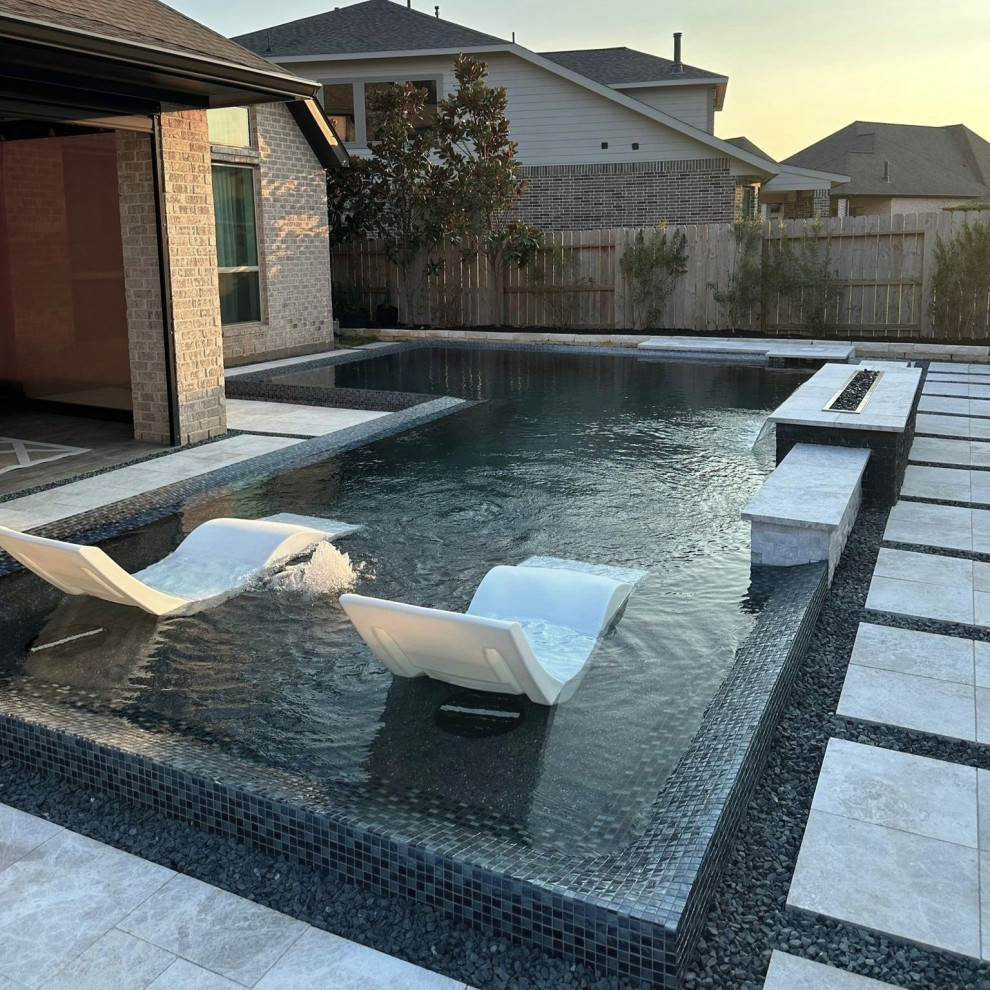 Photo of a modern l-shaped swimming pool in Houston with natural stone paving.