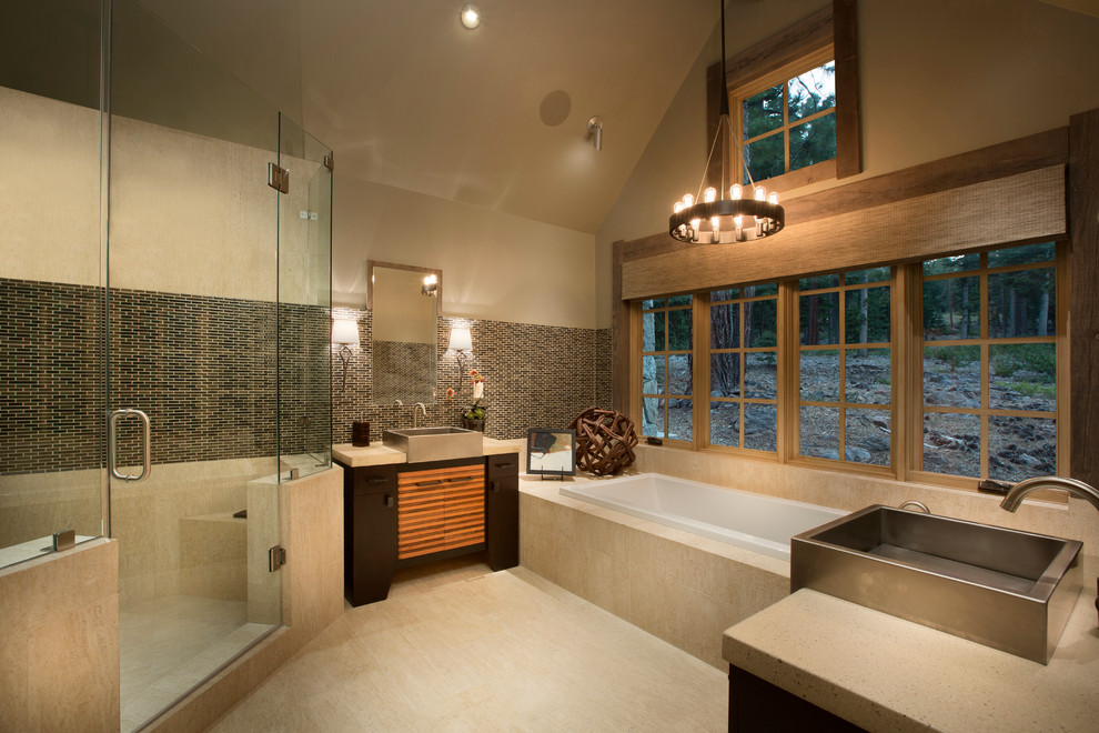 This is an example of a country bathroom in Sacramento with a vessel sink, flat-panel cabinets, dark wood cabinets, a drop-in tub, beige tile and beige walls.