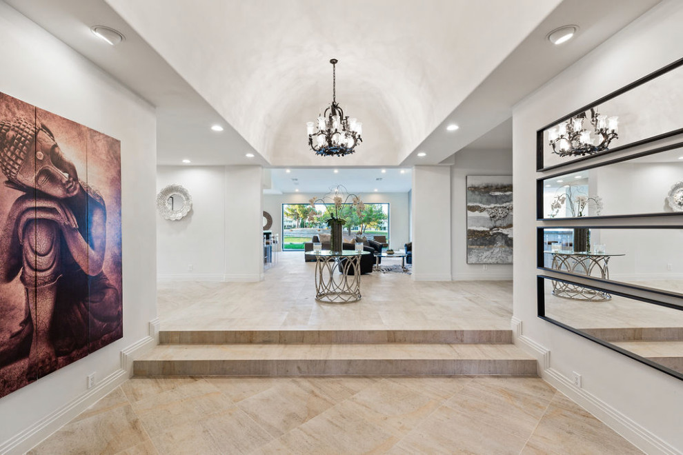 This is an example of a large eclectic foyer in Las Vegas with white walls, marble floors, a double front door, a brown front door, white floor and vaulted.