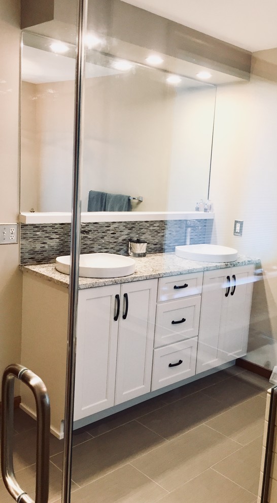Transitional master multicolored tile and mosaic tile porcelain tile and brown floor freestanding bathtub photo with shaker cabinets, white cabinets, a vessel sink, quartz countertops, a hinged shower door and multicolored countertops