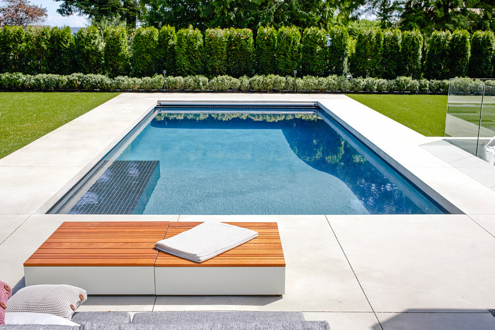 Large contemporary rectangular pool in Vancouver with stamped concrete.