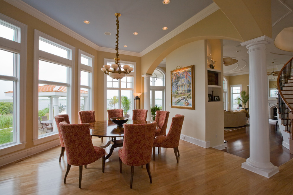 Inspiration for a large transitional light wood floor and beige floor enclosed dining room remodel with yellow walls and no fireplace