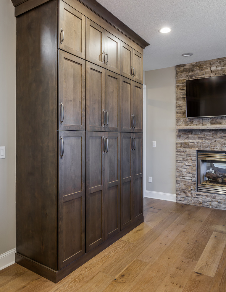 Example of an u-shaped brown floor eat-in kitchen design with a farmhouse sink, shaker cabinets, white cabinets, quartz countertops, white backsplash, subway tile backsplash, stainless steel appliances, an island and white countertops