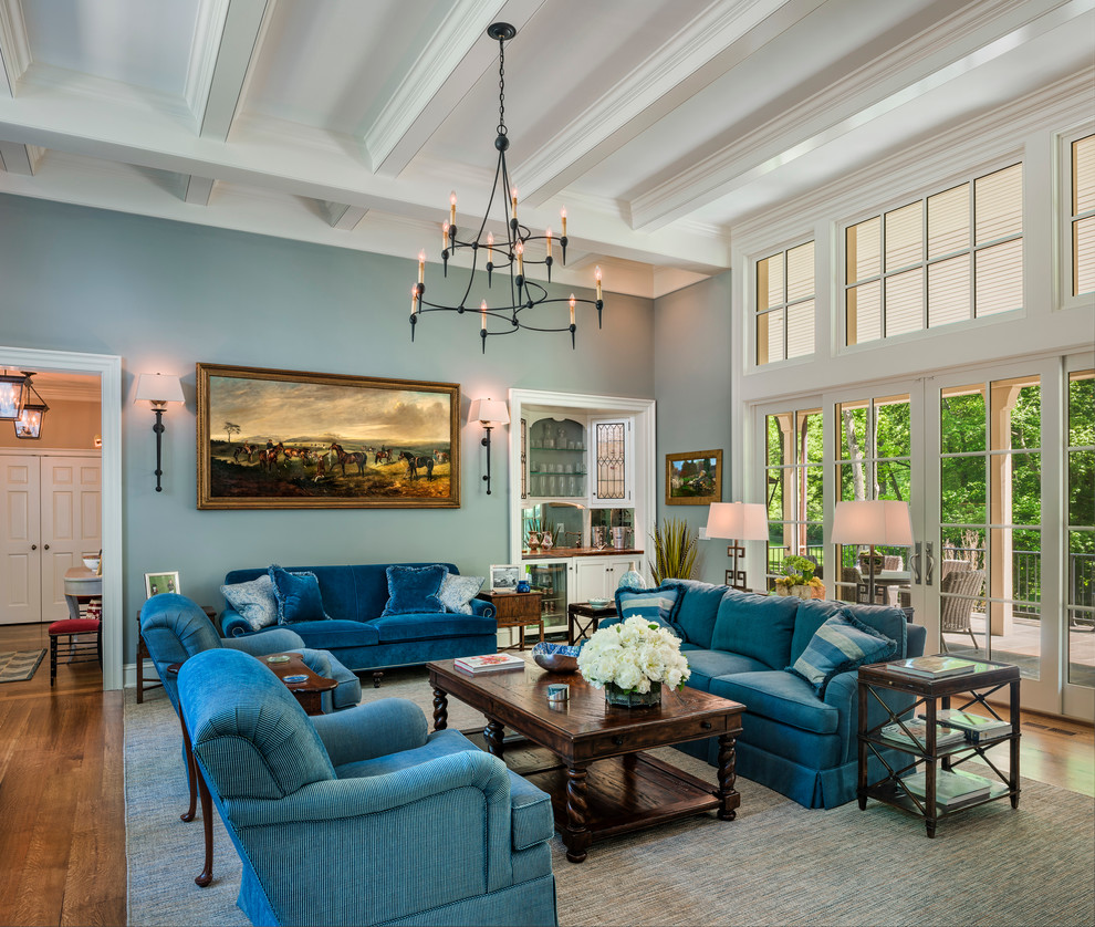 Large traditional open concept living room in Philadelphia with a home bar, blue walls, a standard fireplace, a wood fireplace surround, no tv and medium hardwood floors.
