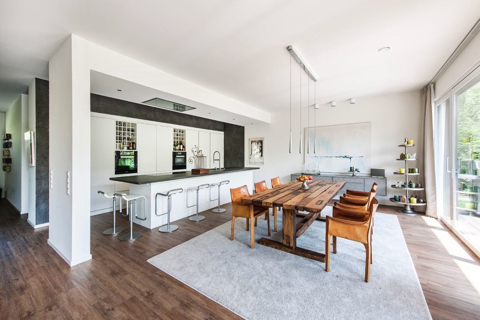 Photo of a large contemporary open plan dining in Hamburg with white walls, dark hardwood floors, brown floor and no fireplace.