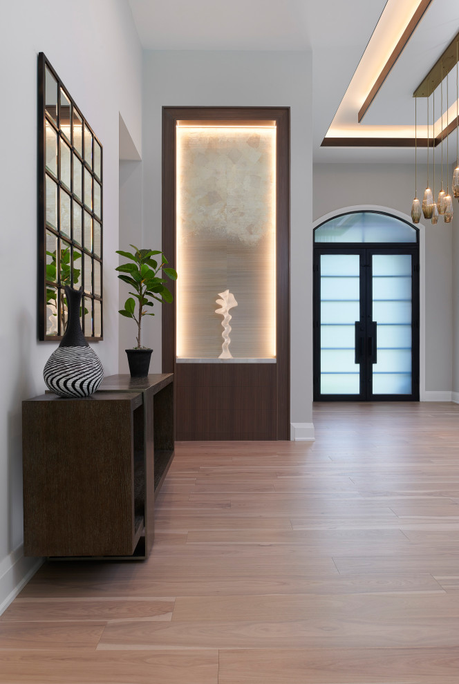 Immagine di un grande ingresso minimal con pareti beige, parquet chiaro, una porta a due ante, una porta nera, pavimento marrone e soffitto a cassettoni